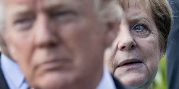 US-Präsident Donald Trump steht vor Bundeskanzlerin Angela Merkel (CDU) am 27.05.2017 beim Familienfoto der G7 Staaten mit den Outreach-Partnern in Taormina auf Sizilien (Italien). Foto: Michael Kappeler/dpa +++(c) dpa - Bildfunk+++