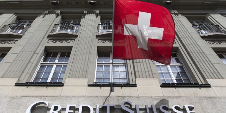 Eine Schweizer Fahne weht ueber dem Credit Suisse Logo bei der Bank Filiale am Bundesplatz, am Donnerstag, 22. Mai 2014 in Bern. (KEYSTONE/Peter Klaunzer)